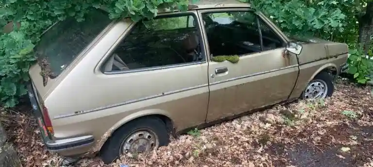 Havererad bil med motorproblem som värderas för försäljning till uppköpare istället för dyr reparation.